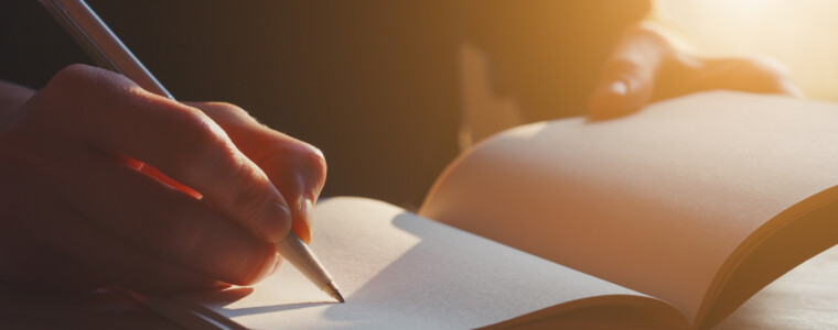 female hands writing notes on notebook with pen