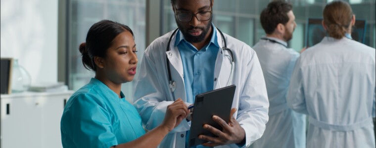 Doctors cooperation teamwork Indian Arabian woman nurse therapist asking advice African American man doctor doc pediatrician therapist practitioner discussing holding digital tablet device at clinic. High quality 4k footage