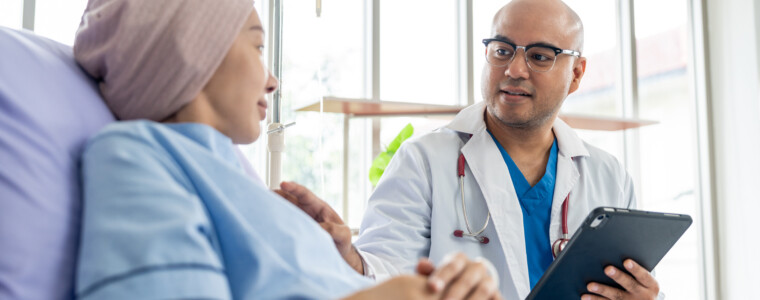 Male doctor visiting female cancer patient with care and compassion in hospital room. Oncology support medical consultation healthcare and hope. Doctor reporting medical test results to the patient