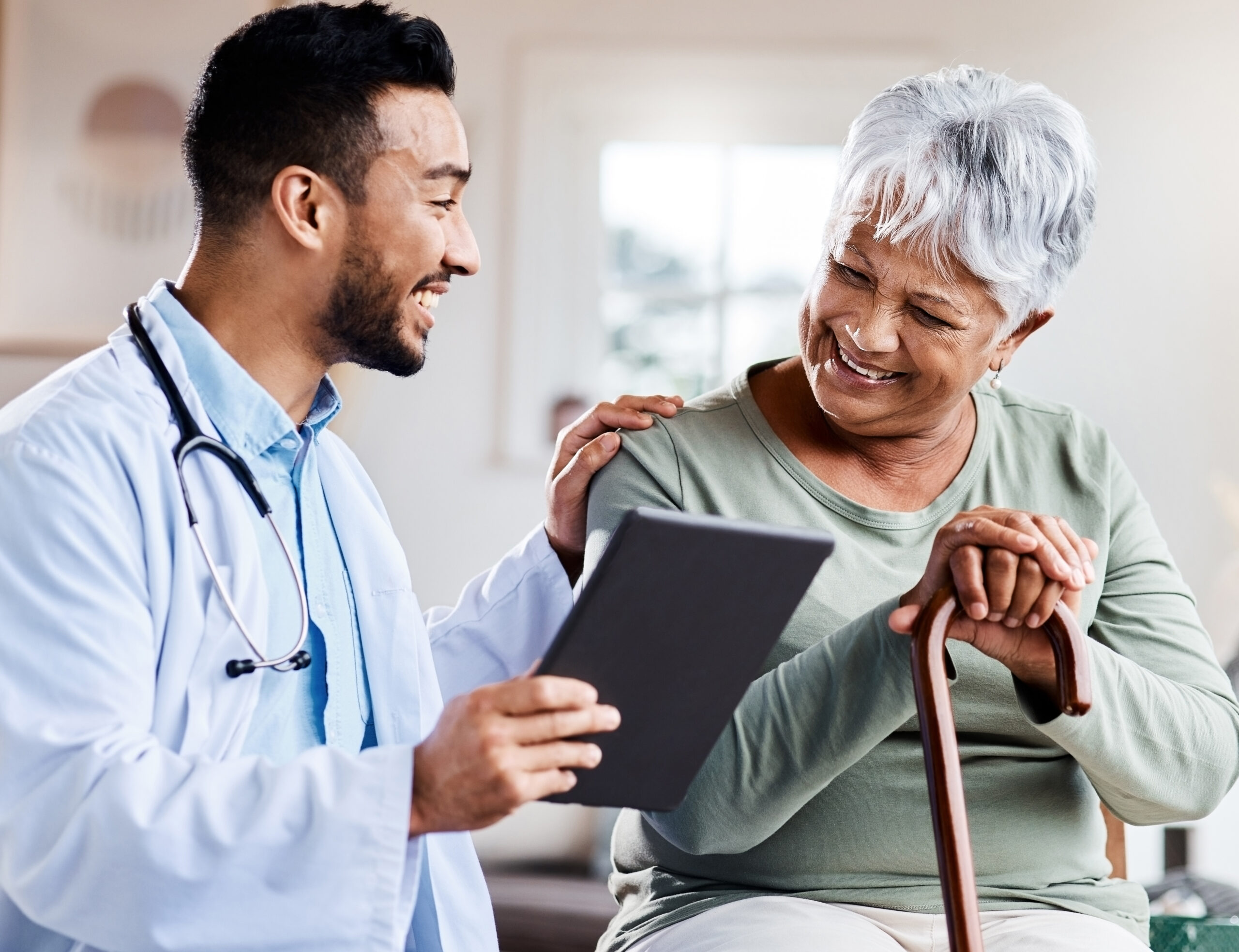 Shot of a young doctor sharing information from his digital tablet with an older patient.
