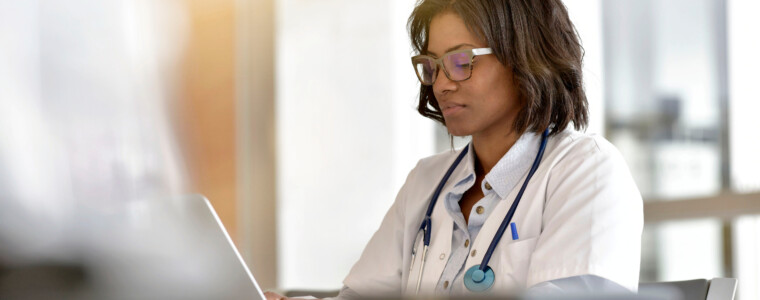 Woman doctor working in office with laptop computer