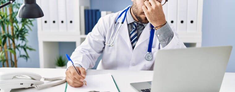 Young hispanic man wearing doctor uniform stressed working at clinic